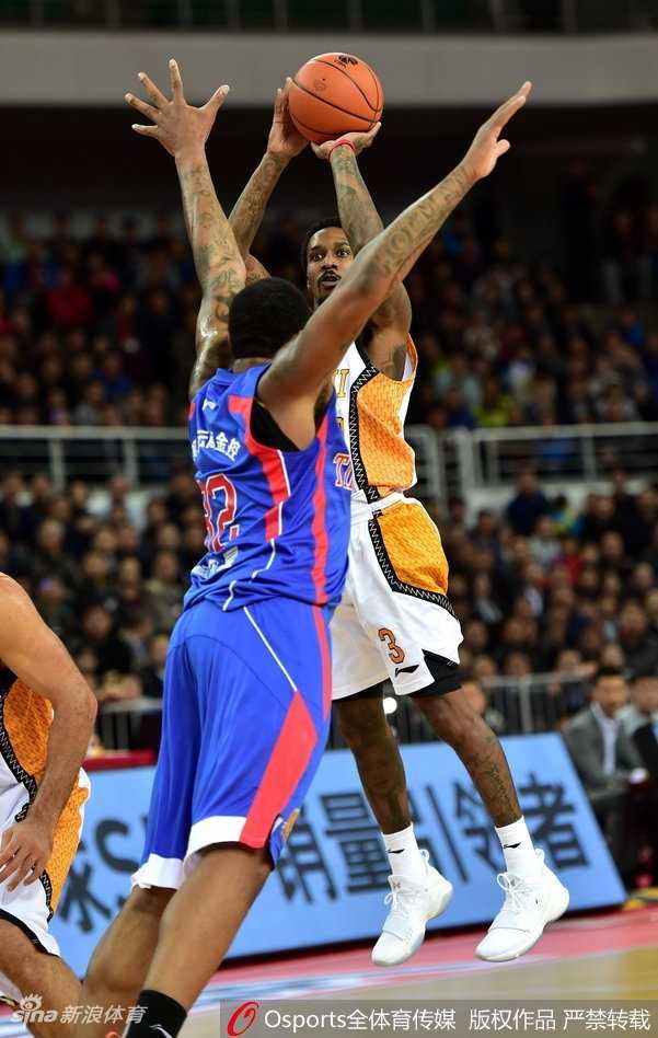 天津队外援霍尔曼在山西队内线群中奋力起跳，用指尖将球点向自己队友的方向，拼抢前场篮板。