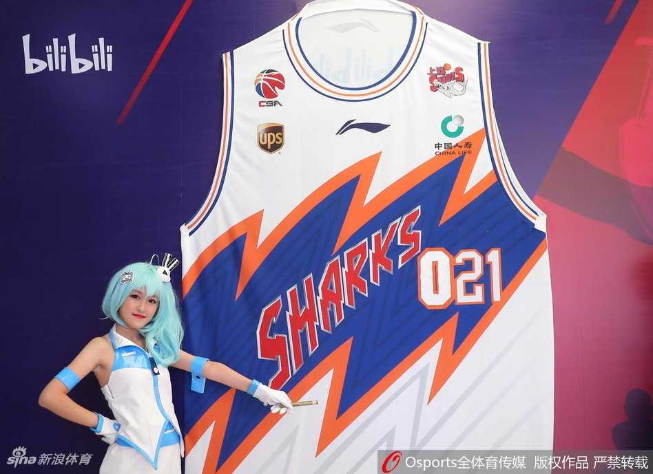 终身荣誉球迷徐光启老夫妇在仪式现场接受全队致敬，老爷爷手中拿着纪念球衣，老奶奶笑容慈祥，在他们身后，是充满活力的二次元背景板，这一刻，传承与创新完美交融。