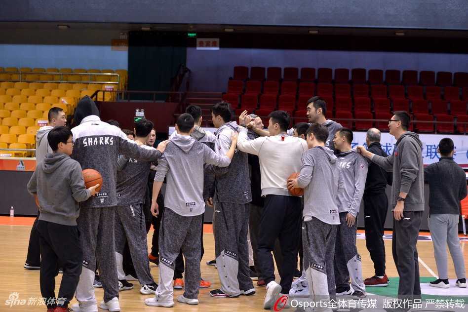 赛后，上海男篮球员们神情凝重地走回更衣室，背景是巨大的比分牌，92-117的数字显得格外刺眼，但球员的背影依然挺拔。