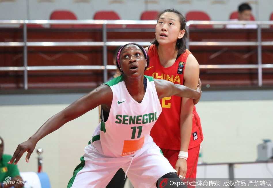 在激烈的内线对抗中，中国女篮队员李梦凭借强壮的身体卡住有利位置，高高跃起摘得篮板球，眼神中透露出必胜的信念。