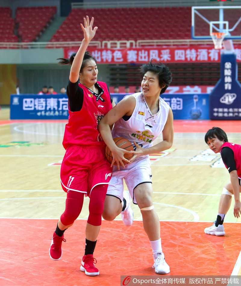 八一女篮球员在对手篮下高高跃起，以一记精彩的补篮点燃全场观众的热情