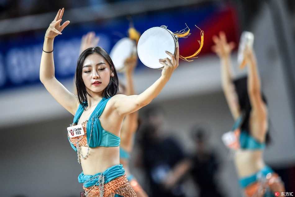 亚冠决赛新疆男篮卫冕梦碎 异国风情宝贝热舞打鼓抢镜 清凉装扮的宝贝们全神贯注地演奏着手鼓,统一的红色着装如同火焰,与赛场上的激烈对抗相得益彰,成为看台上一道移动的风景线。
