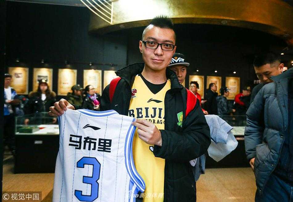 签售现场，一位得到签名的女球迷激动地展示着马布里的亲笔签名，喜悦之情溢于言表