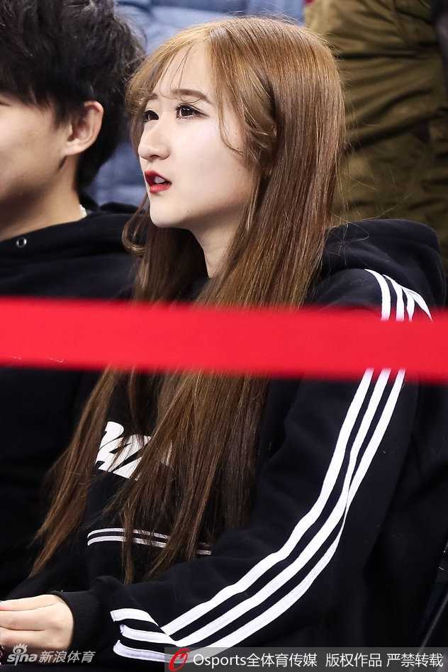 京城冬日的一抹暖色:五棵松美女球迷点燃赛场激情 长发披肩的女生轻倚在栏杆旁,唇红齿白,眉眼间带着浅浅的笑意,她像是从画中走出的校园学姐,恰好路过这片热血沸腾的战场。