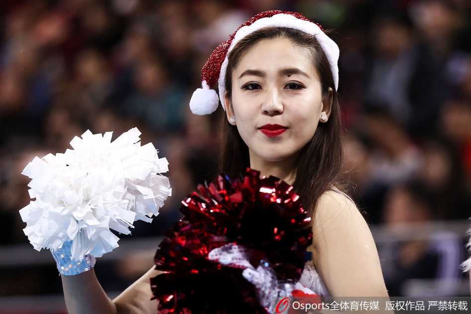 京城圣诞夜的红色热浪:北京首钢篮球宝贝冬日特别表演 聚光灯下,一位宝贝正全情投入地舞动,即使是一个简单的托腮动作也充满了俏皮与活力,身后的队友虚化成斑斓的光影,仿佛整个舞台都为她们的青春喝彩。