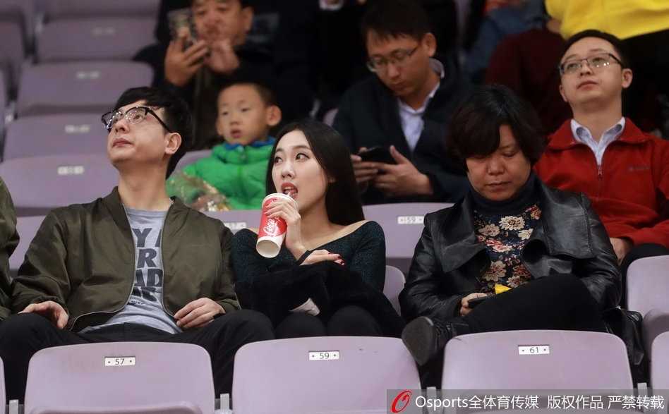 京城新势力御敌记:马布里率北控力斩山东高速,场边美女球迷成另类风景 一位身穿白色休闲服的清秀女球迷,双手轻托脸颊,目光专注地望向赛场方向,眼神中流露出对比赛进程的紧张与期待。