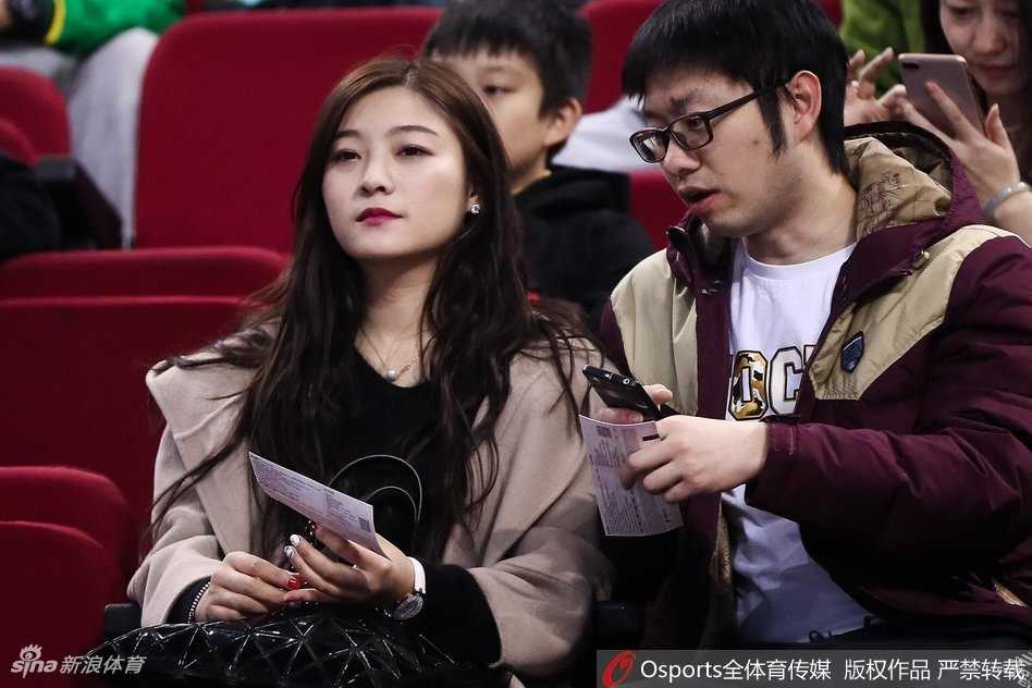 京城篮球之夜,美女球迷点亮看台风景线 在人群的缝隙中,一位戴着黑框眼镜的美女球迷神情专注地凝视着远方。她的手里拿着北京男篮的应援围巾,安静的气质与身后喧嚣的看台形成一种独特的和谐,仿佛一位冷静的记录者。