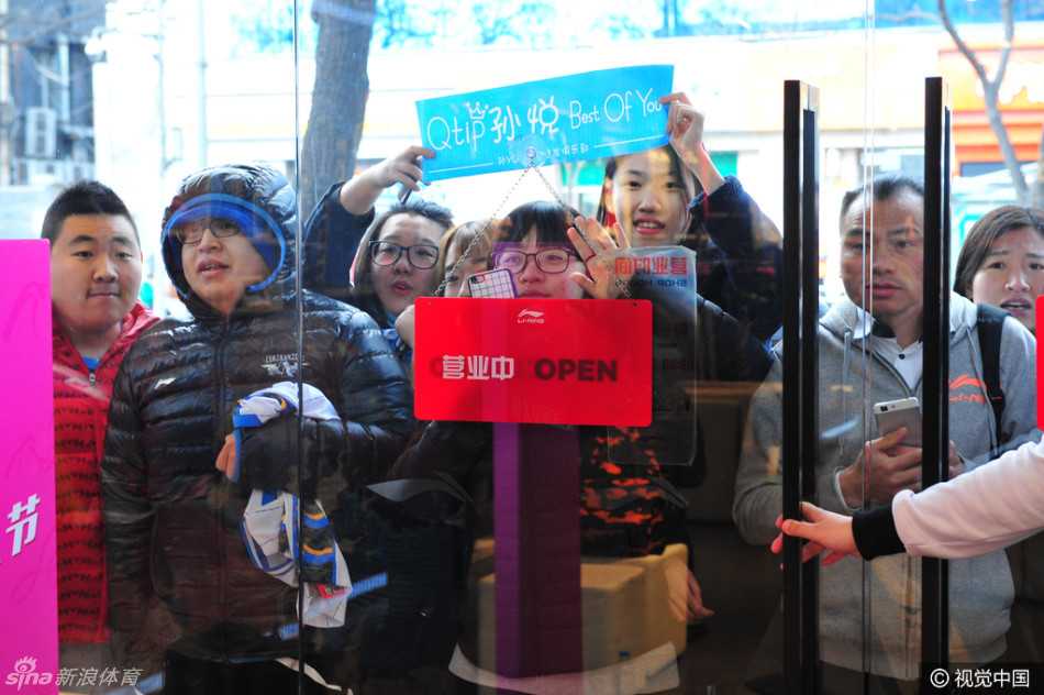 活动现场人头攒动，孙悦和方硕站在背景板前，与热情高涨的球迷们进行大合影，大家比出加油的手势，记录下这美好的团聚时光