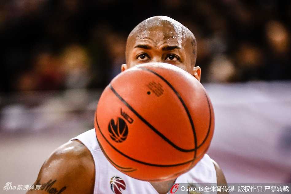 北控外援费尔德面对山西队两人的包夹防守，眼神坚毅，奋力将球举过头顶寻找队友