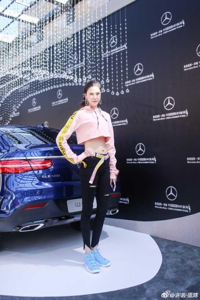 许诺面带清爽妆容对镜浅笑，粉色系穿搭衬托出她的好气色，露脐装设计小秀腹肌轮廓，健康又迷人。