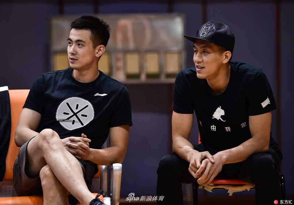 赵继伟与郭艾伦并肩坐在场下，赵继伟双手抱在胸前，表情严肃，两人正低声交流着场上的局势