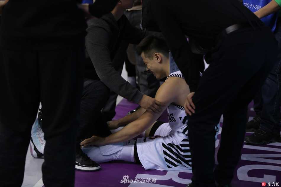 辽宁队医紧急入场查看伤情，赵继伟躺在地板上，眼神中充满了不甘与无奈。