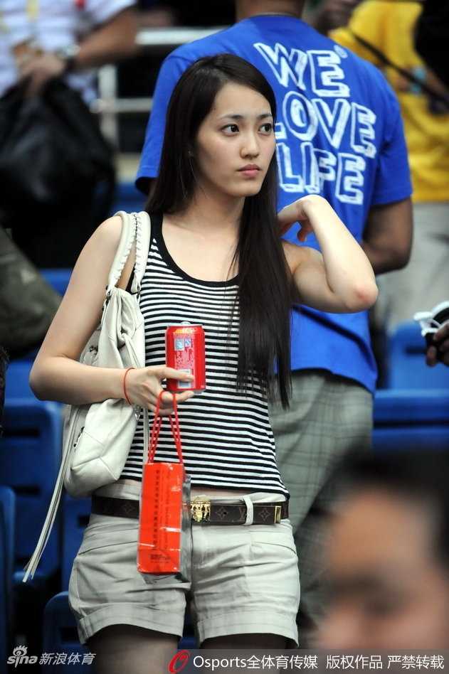 王棠云身着简约白色上衣坐在球场边，回眸瞬间秀发轻扬，眼神温柔似水透着大家闺秀的典雅气质