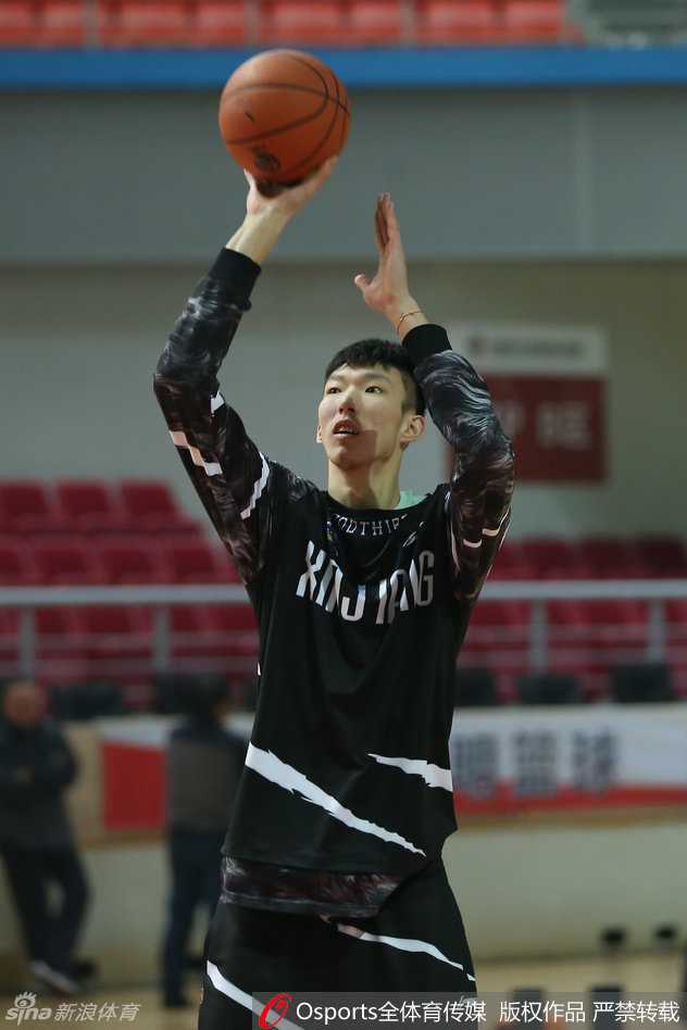 周琦在训练间隙拉伸身体，他那修长的手臂高高扬起，巨大的手掌仿佛能遮蔽天空，这位“大魔王”的防守威慑力将是新疆取胜的关键。