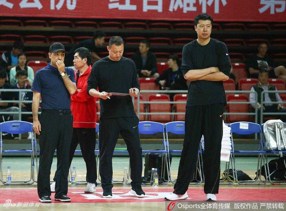 球场边的王治郅神情专注，双手抱胸的他仿佛一座灯塔，用深邃的篮球智慧为场上弟子们指引方向。