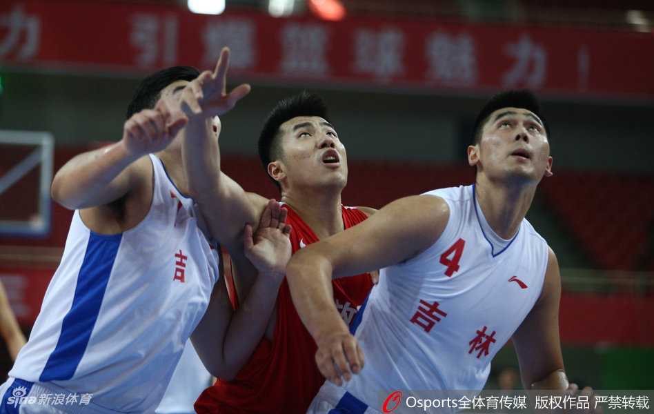 解放军内线核心邹雨宸在吉林队多名球员的包围下，高高跃起，用强壮的手臂将篮板球牢牢控制在手中，眼神中充满了对胜利的渴望。