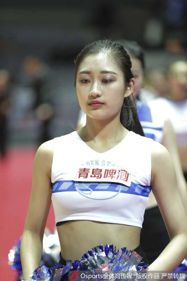 在绚丽的灯光下，三位篮球宝贝排成一排，同时做出踢腿动作，展现出惊人的柔韧性与协调性，动感的画面让人仿佛能听到现场震耳欲聋的音乐声。