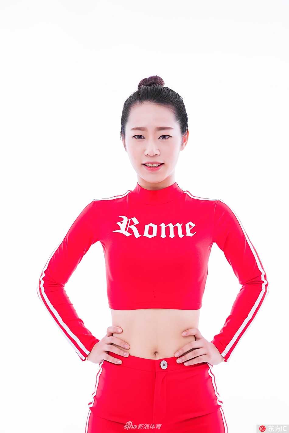 一位宝贝单手叉腰，身体曲线呈现出完美的S形，紧身的衣料反射着摄影棚的灯光，凸显出她经过长期训练才拥有的紧致肌肉线条，既有女性的柔美，又不失运动的力量感。