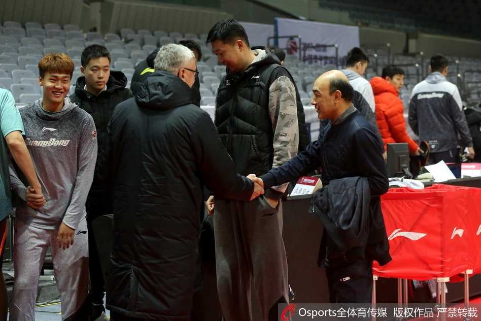 尤纳斯准备离开训练场时，回头望向正在指挥训练的王治郅，眼中充满欣慰与期许，仿佛在看着自己最得意的作品。场边的灯光将两人的影子拉得很长很长。