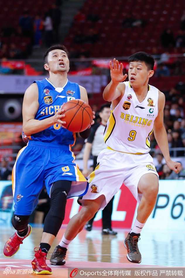 北控队教练组在暂停时围成一圈，主教练手握战术板大声布置，球员们神情专注，正在为最后一搏制定策略。