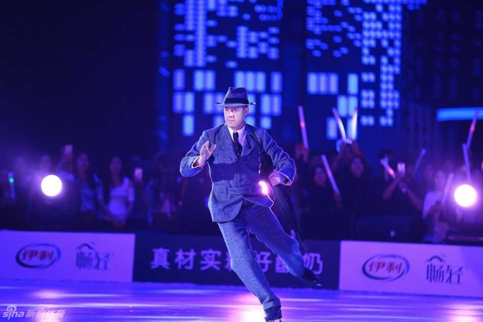 花滑王子普鲁申科在水立方的背景板前留下帅气身影，他身穿深蓝色西装，双手自然垂放，面带标志性的微笑，气质优雅从容。