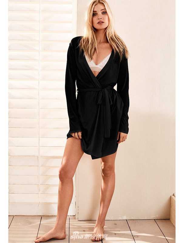 艾尔莎在厨房的一角回眸，光影交错间，她的侧影曼妙而优雅，背景的瓶罐碗碟也为这幅画面增添了几分亲切的生活烟火气。