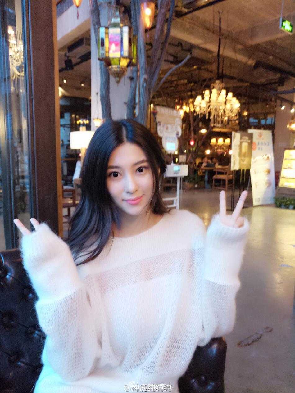 钟鹿纯身穿白色清新吊带裙，在海边回眸一笑，温柔的海风轻拂她的发丝，尽显优雅女神范儿。