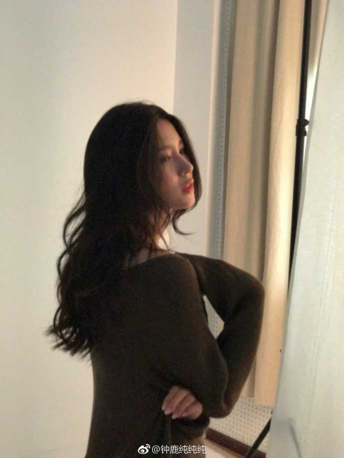 钟鹿纯身穿一件带有图案的时尚卫衣，歪着头看向镜头，眼神中透着一丝俏皮和灵动，展现出她性格中活泼可爱、古灵精怪的一面。