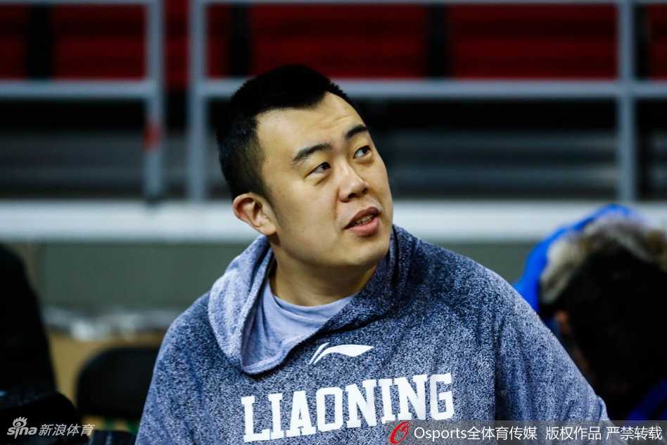 辽宁队的其他队员在远处进行拉伸训练，而韩德君则成为了场边的焦点，他抱球回走的背影显得格外高大，充满了安全感。