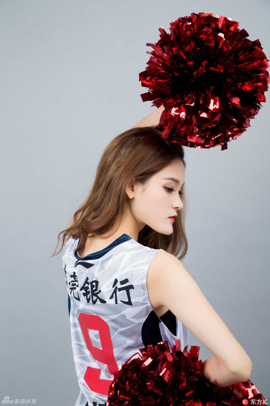 球场中央，多名身穿白色上衣的篮球宝贝排成整齐队列，随着动感音乐挥舞手臂，她们身后是巨大的华南虎队徽，这一刻她们是守护主队荣耀的美丽使者。