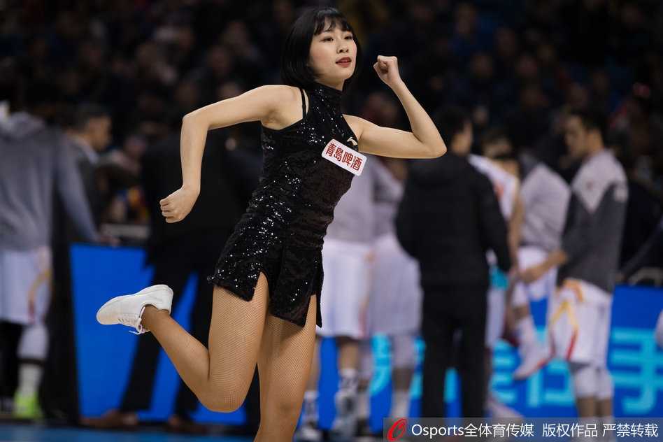 篮球宝贝们随着劲爆的音乐整齐地挥动手臂，她们脸上洋溢着灿烂的笑容，仿佛冬日里的暖阳，瞬间驱散了看台上的寒意。