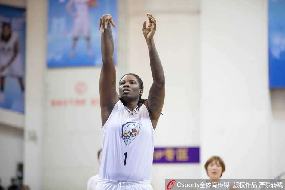 广东女篮主教练在场边激情指挥，他张大了嘴巴，双手比划着战术手势，神情专注而严肃，试图通过呐喊稳住场上的局面。