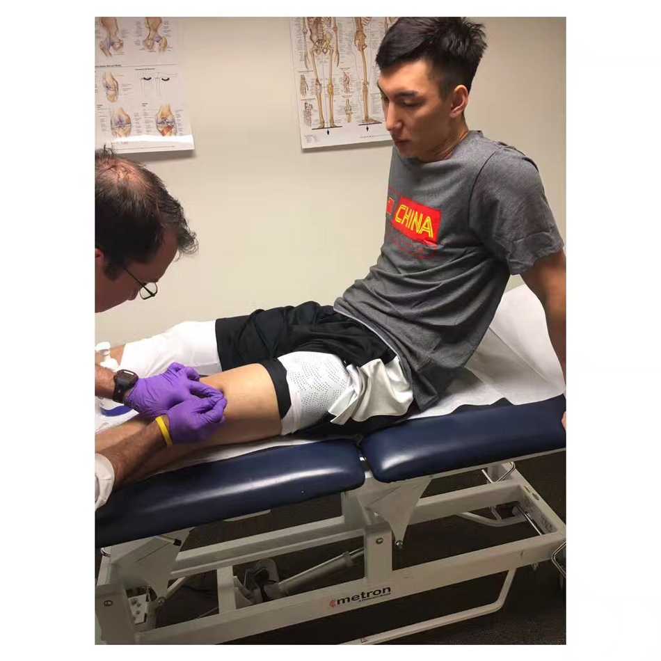 治疗师专注地用手法处理可兰白克的伤处，指尖精准地按压在痛点，而可兰白克则用手支撑着头部，目光望向远方，或许是在憧憬满血归来的那一刻。