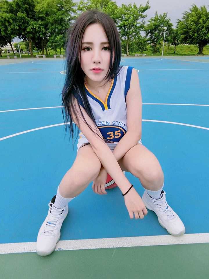 身穿緊身勇士T恤的心心兒，專注地看著遠方，微風吹亂了她的髮絲，卻吹不散她對籃球的熱愛。