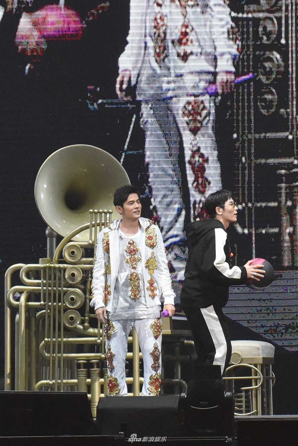 周杰伦与萧敬腾在台北小巨蛋的舞台上背对背坐着，周董坐在大喇叭造型钢琴前弹奏，两人深情合唱，画面充满音乐才子间的惺惺相惜。