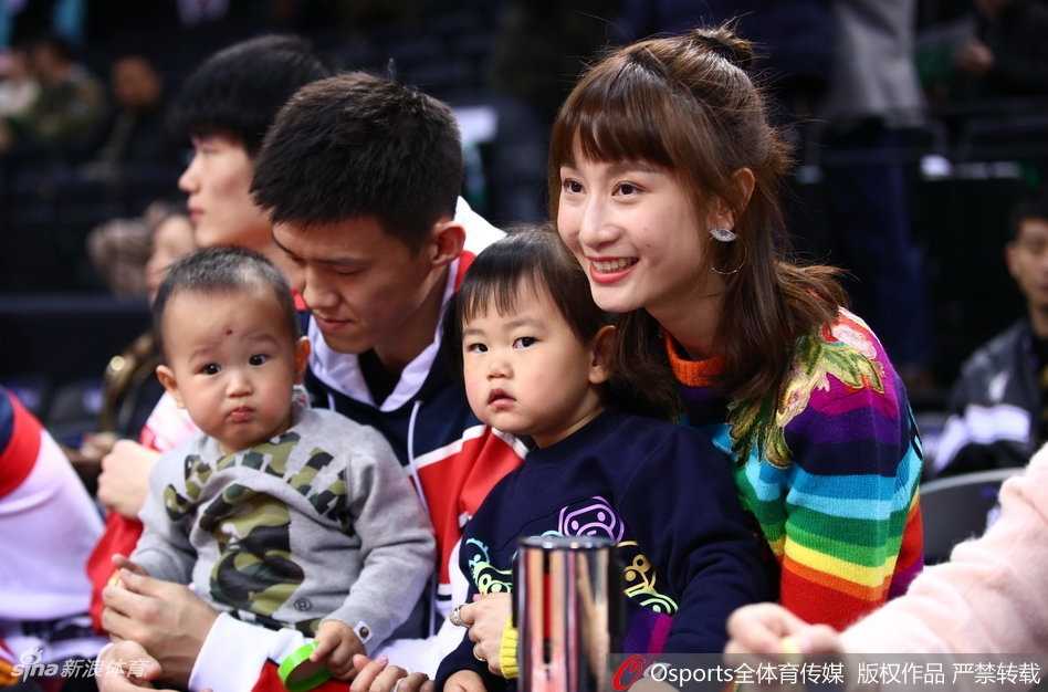 周鹏的儿子活泼好动，在爸爸的看护下站立在座位上，刘美则细心地为女儿整理着衣领，一家四口在喧嚣的赛场中营造出属于自家的小天地