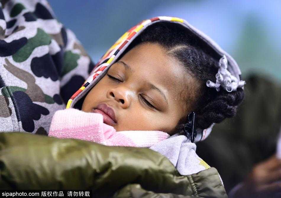 哈德森大女儿扎着马尾辫，全神贯注地盯着球场，小手放在膝盖上，眼神里满是对爸爸的崇拜与关切。