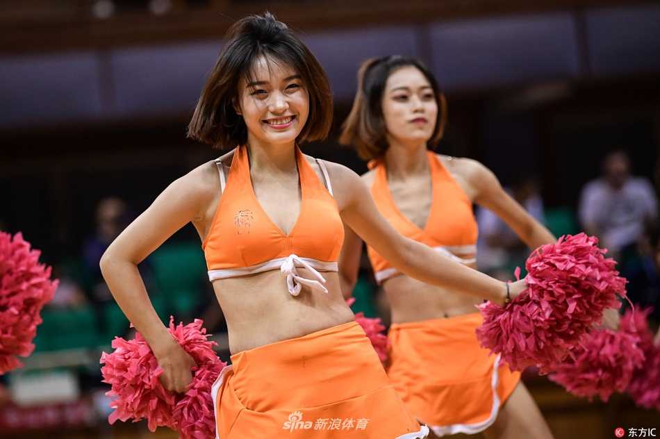 在球场地板的倒映下，啦啦队完成集体托举动作，展现了团队默契与高超的舞蹈技巧