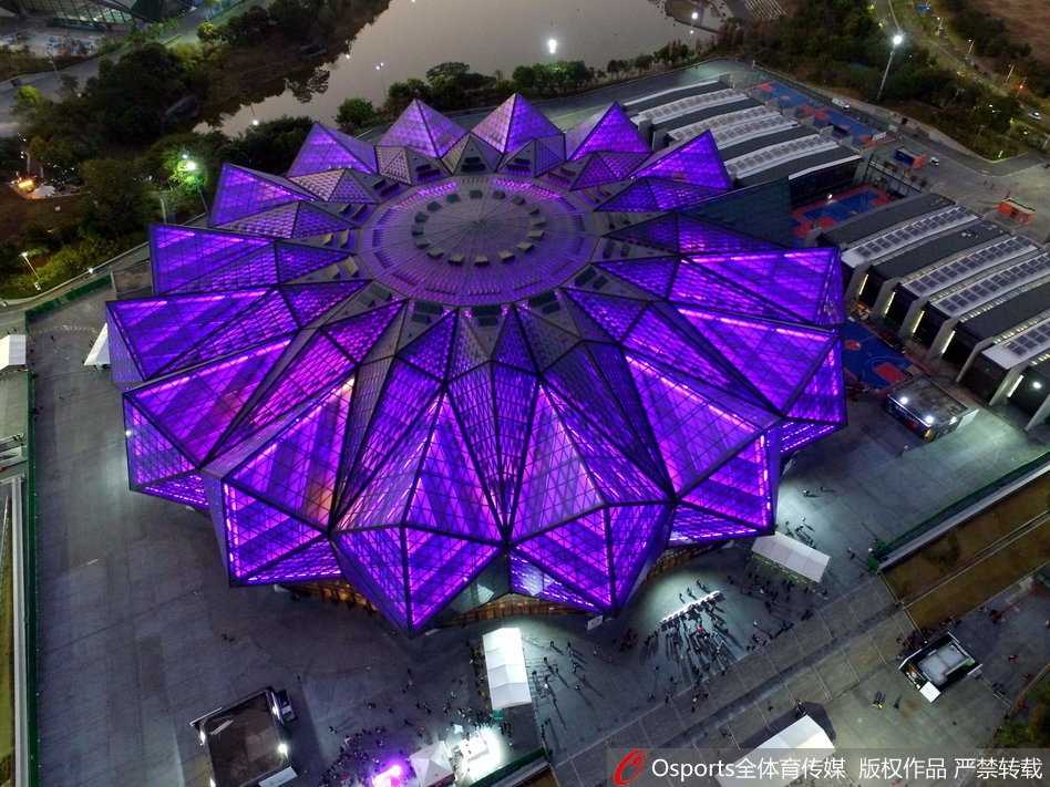 易建联在比赛中高高跃起，单手抓球试图完成一次势大力沉的灌篮，他的眼神坚定，对手在他面前仿佛已成背景。