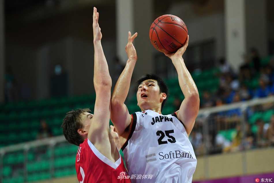 日本队后卫面对挪威队高大的防守球员，依然冷静地寻找传球路线，他的队友正在通过无球跑动试图拉开空间，现场观众的背景虚化处理突出了场上紧张的气氛。