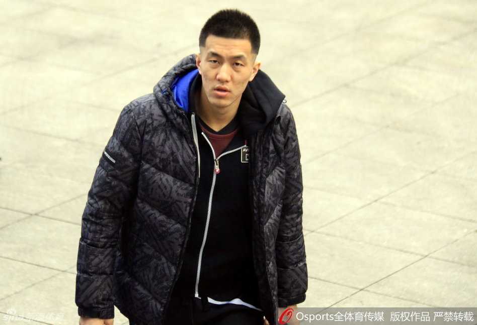  郭艾伦眼神有些迷茫地坐在场边，双手抱着篮球，表情呆萌可爱，与场上激烈的备战节奏形成了一种有趣的反差萌。