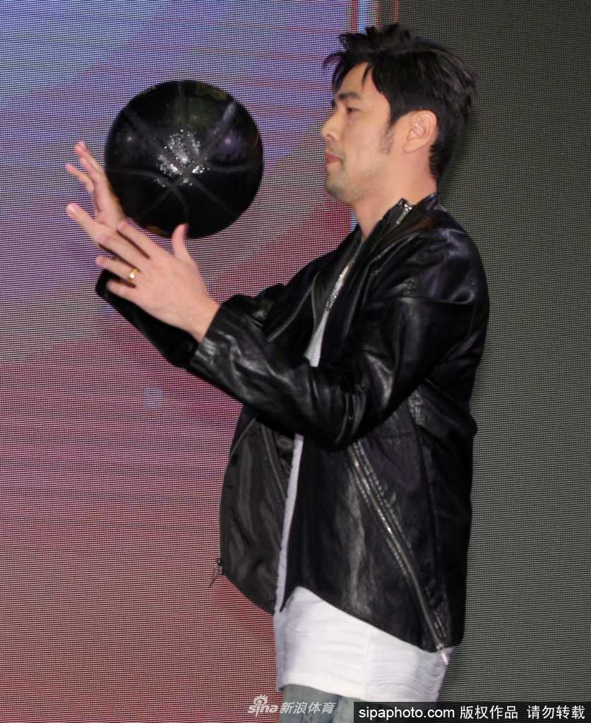 周杰伦单手轻松抓球，脸上露出自信而俏皮的笑容，仿佛在向镜头宣告：这片球场我说了算。