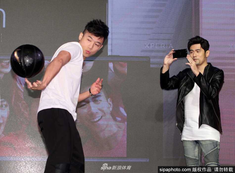 周杰伦聚精会神地盯着手中的篮球，正准备来一个花哨的胯下运球，动作虽不专业却颇具喜感。