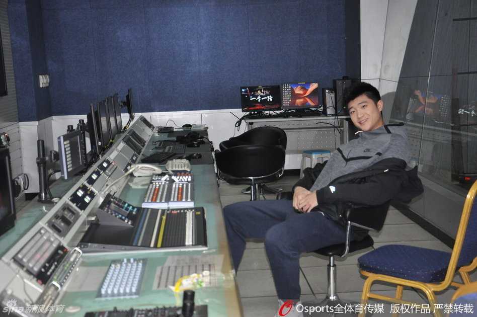 导播间内，身穿休闲装的李敬宇双手插兜，好奇地观察着满墙的监视器和忙碌的工作人员，他对电视节目的制作流程充满了新鲜感，脸上挂着憨厚的笑容。