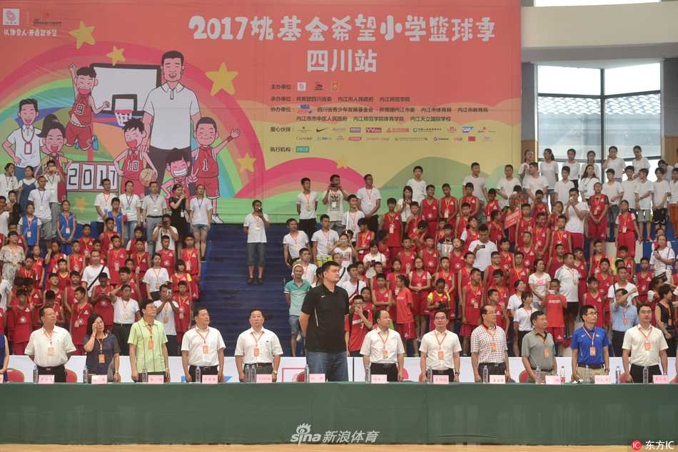 内江天立国际学校的体育馆内，巨大的横幅下，姚明正与主办方领导及全体获奖队伍合影，场面宏大而温馨，记录下2017年这个充满爱心与活力的篮球盛夏