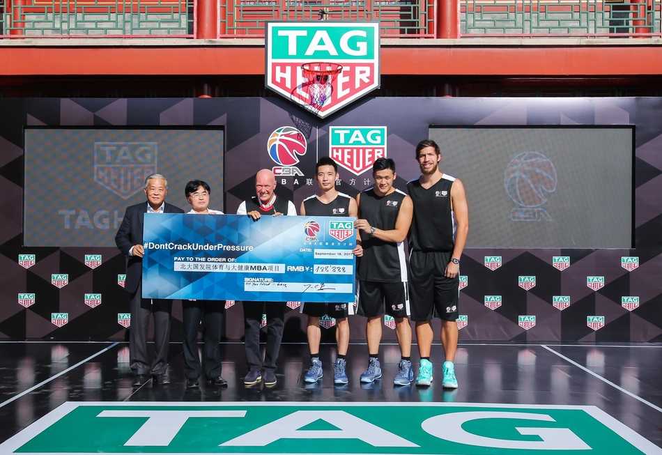 姚明与泰格豪雅首席执行官让-克劳德·比弗在签约台上双手紧握，背景是巨大的签约板，两人脸上洋溢着合作共赢的喜悦，象征着彼此信任的重新建立。