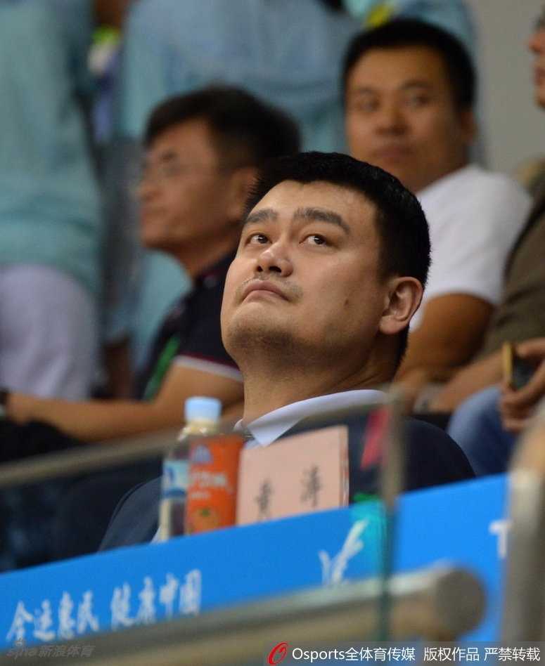 姚明在颁奖仪式上弯腰为广东队球员佩戴金牌，巨大的身形与年轻球员形成鲜明对比，他脸上的笑容满是对中国篮球后浪的欣慰。