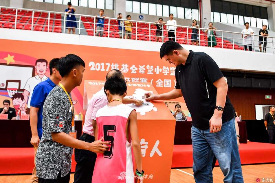 姚明在众人的簇拥下步入会场，他面带标志性的亲和笑容，一边走一边与身旁来自南京及全国各地的青少年们挥手致意，气氛热烈非凡。