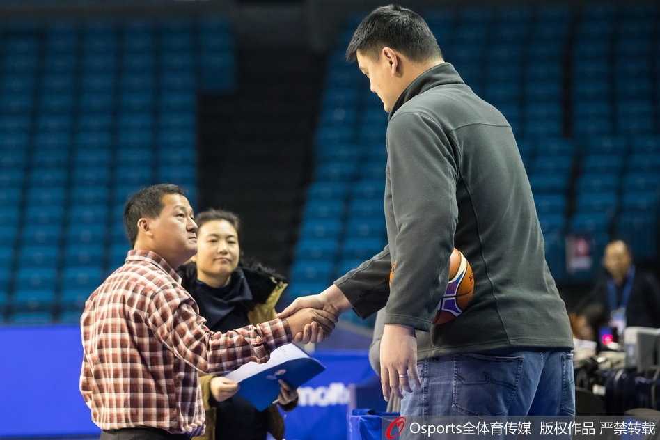 李楠指导手持战术板，拉着一名球员细心讲解跑位路线，眼神交流中传递着战术的精髓与信任。