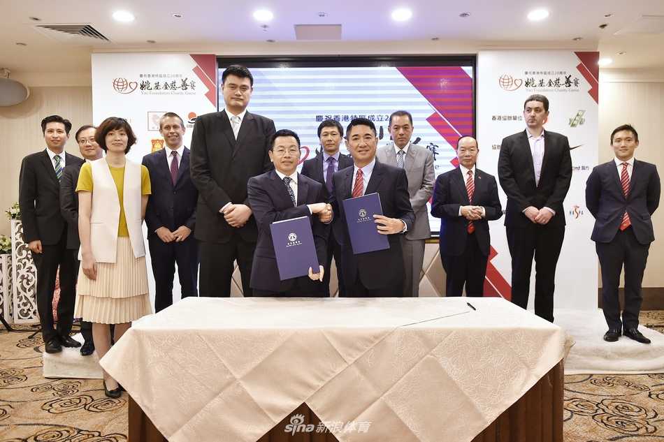 姚明与多位身着正装的嘉宾并肩而立，众人面对镜头露出灿烂的笑容，定格下了记者招待会上这一其乐融融而又意义非凡的瞬间。